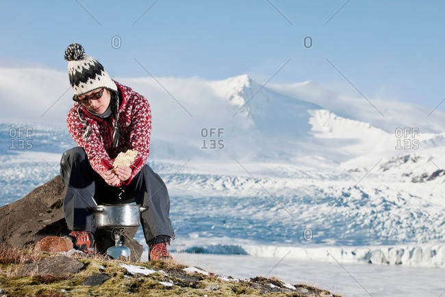 Hiker cooking in snowy landscape