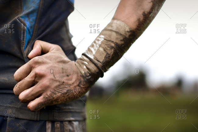 Dirt and mud covering a rugby player\'s hand.