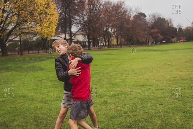 Brothers wrestling for fun in park