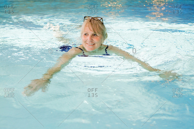 Older woman swimming in pool