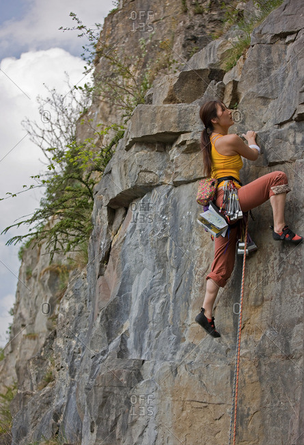 Woman climbing rocky mountainside