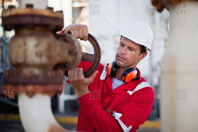 Worker adjusting gauge at chemical plant