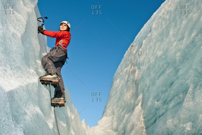 Climber scaling glacier wall