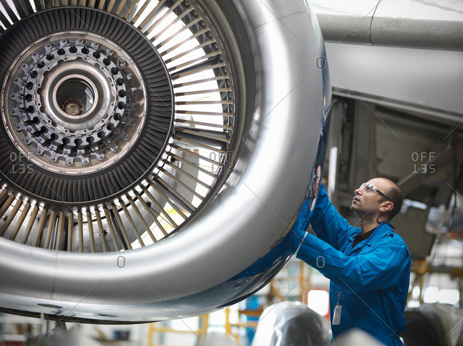 Aircraft engineer working on 737 jet engine in airport