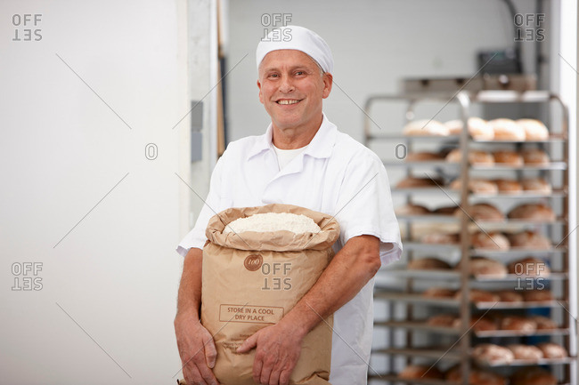Chef carrying sack of flour in kitchen