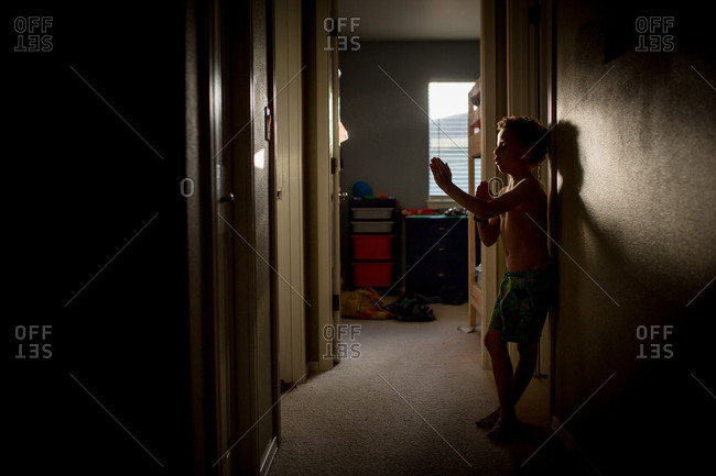 Boy practicing martial arts in a dark hallway