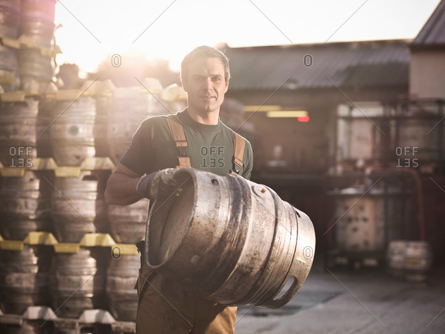 Worker with barrel outside brewery