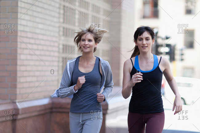 Women running together on city street