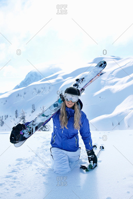 Skier carrying skis in snow