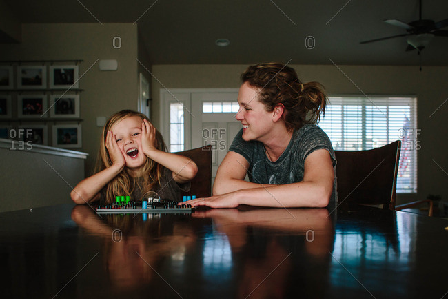 Boy reacting playing board game with mom