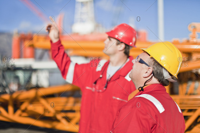 Workers talking on oil rig