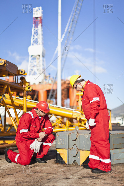 Workers on oil rig examining equipment