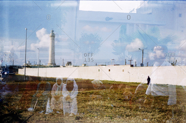 Double exposition 120film people sitting in the street on seaside landscape