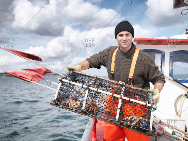 Fisherman with lobster pot and crabs