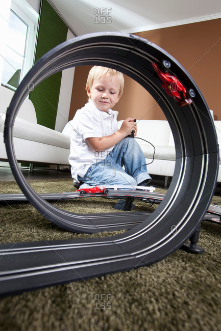 Boy playing with slot car racing track