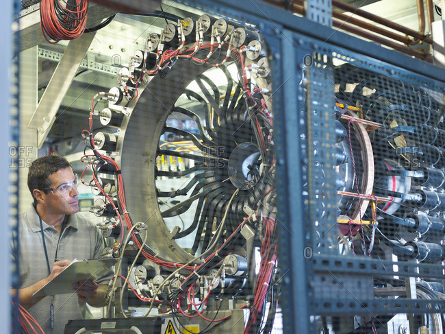 Male scientist inspects particle accelerator