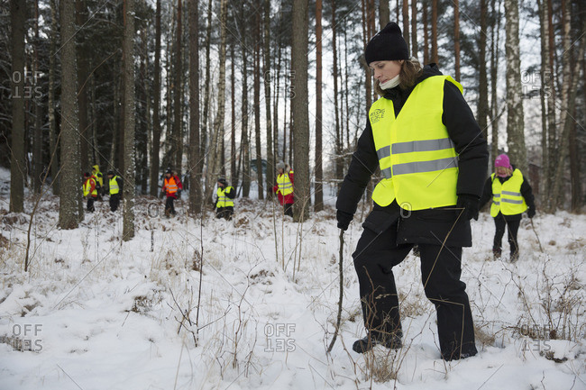 Sweden, Uppland, Upplands Vasby, Volunteers of Missing people organization in winter forest