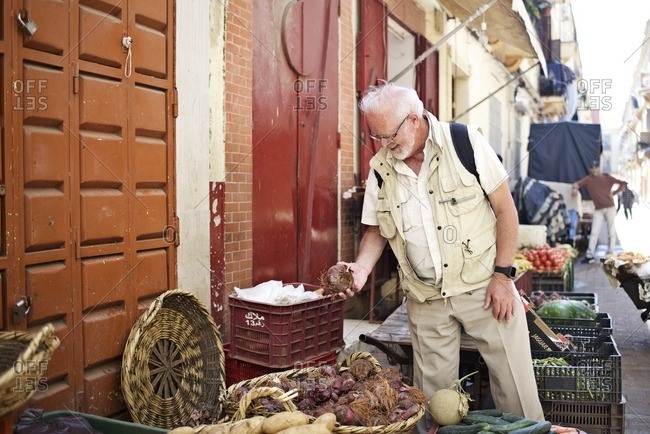 Senior man shopping for produce in outdoor market