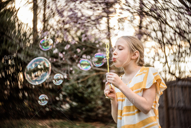 Preteen Girl Blowing Bubbles Offset Stock Photo OFFSET
