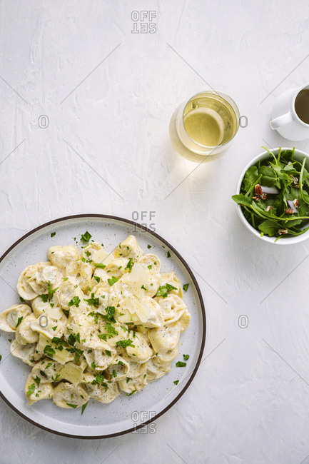 plate of tortellini served with a side salad
