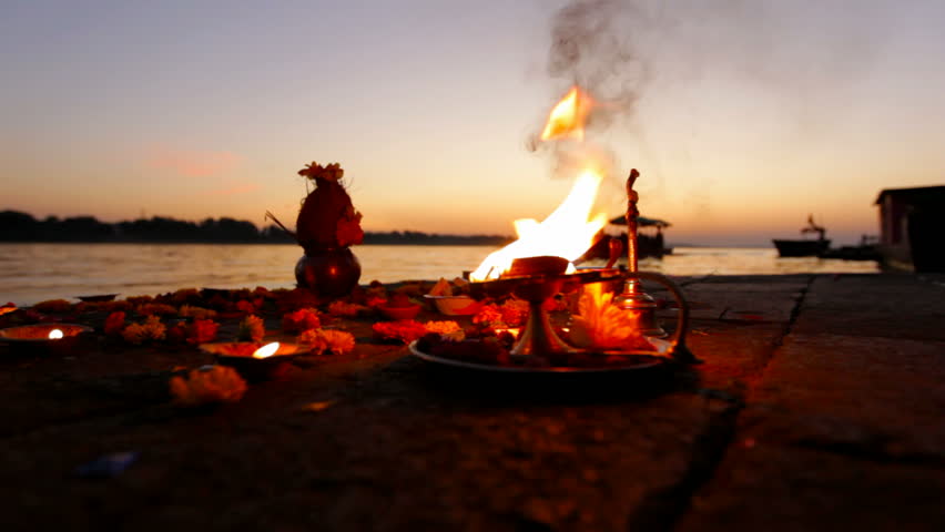 Boat passing next to prayer offerings made on the banks of River Ganges in India.  