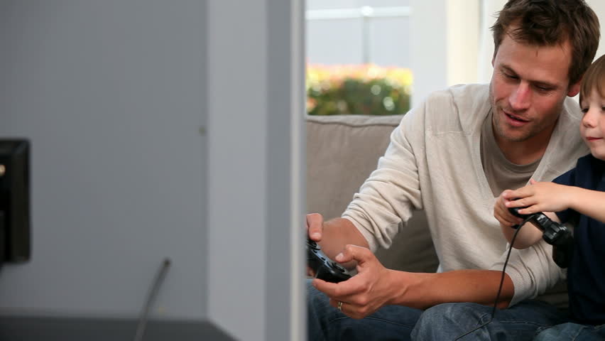 Little boy playing videogames with his father