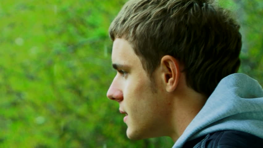 A young man with a camera photographing beautiful green scenery.