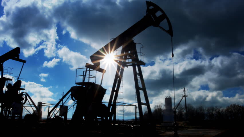 working oil pumps silhouette against timelapse clouds