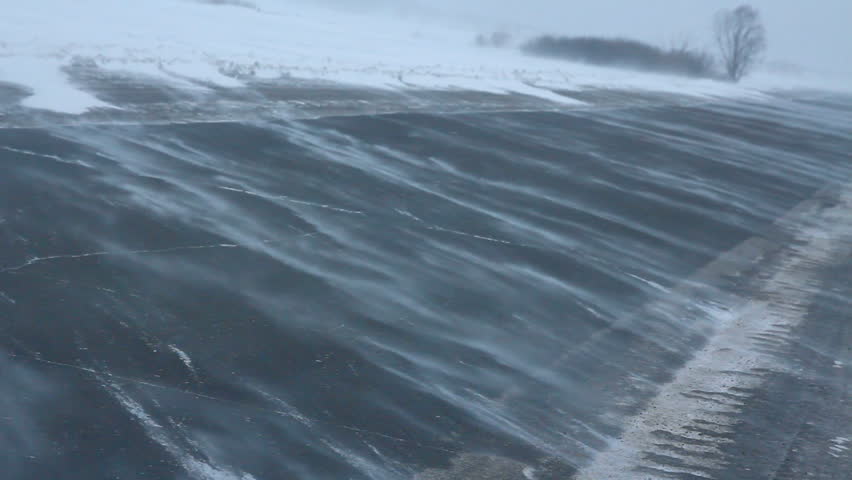 cars on winter road at blizzard