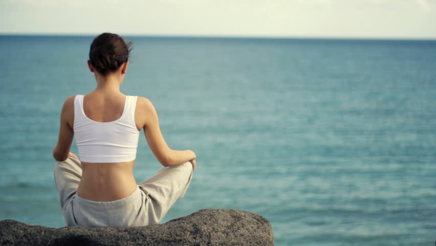 Woman meditating by the sea