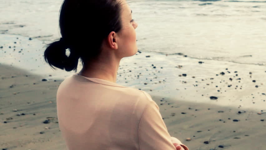 Young woman thoughtfully looking out to sea