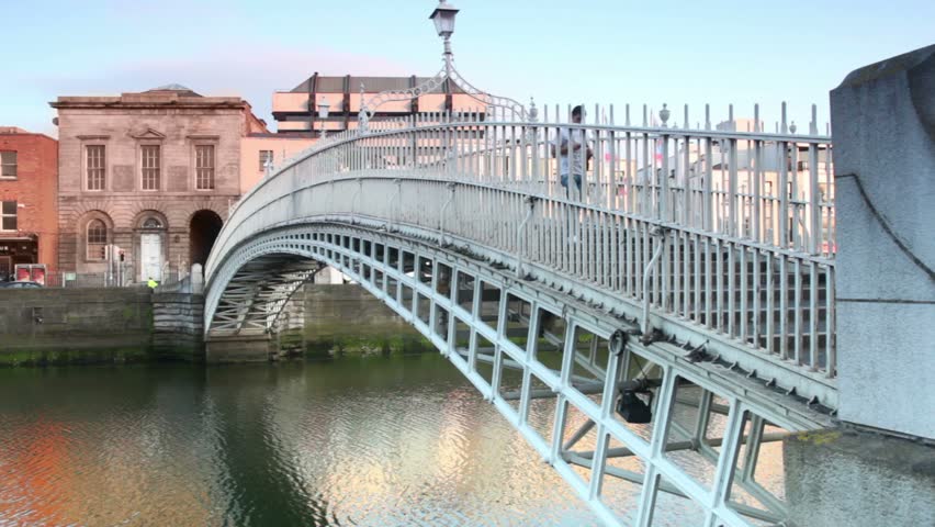  DUBLIN - JUNE 10: People crosses The Ha'penny Bridge through Liffey river, June 10, 2010 in Dublin, Ireland. The Ha'penny Bridge , built in 1816, is the oldest pedestrian bridge over the Liffey River.