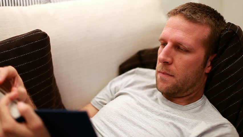 Man reading on sofa. A moment of relaxation after work.