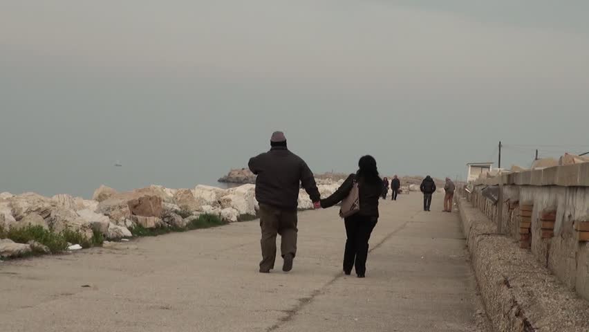 Fat woman and a man walking on the beach