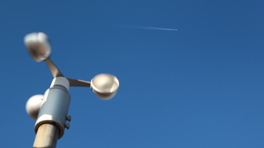 rotary vane for measuring wind speed at airport against blue sky with moving it away by plane