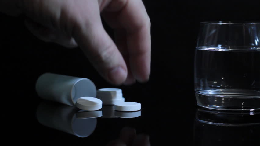 hand of man throws an antacid tablet into a glass of water. dolly shot. 