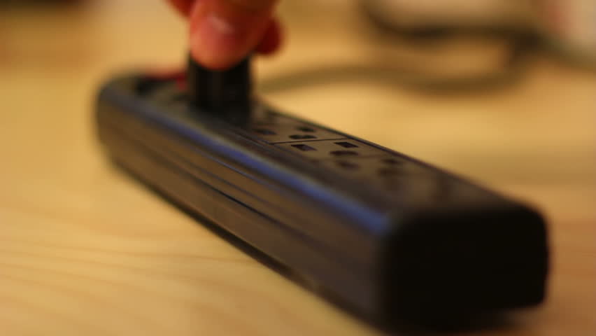 Close-up of plugging in power cords into a power strip.