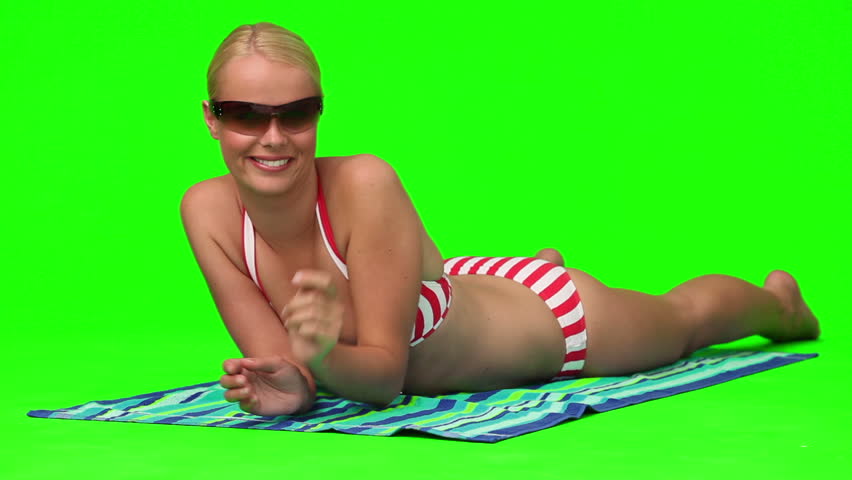 Wonderful blond woman with sunglasses on the beach against a green screen