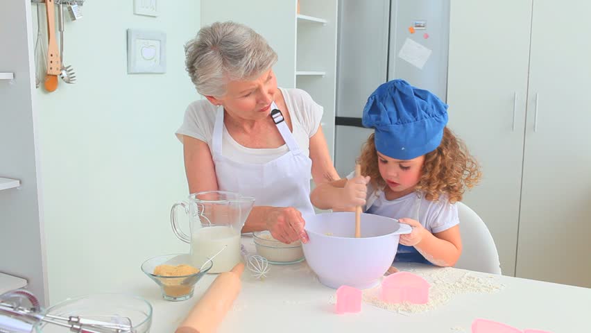 Grandmother cooking with her grand daughter in the kitchen