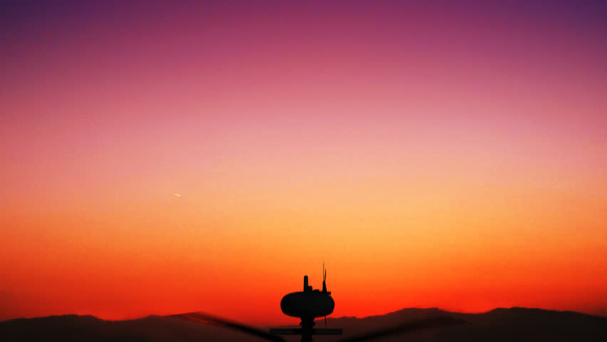 Animation of an Apache helicopter hovering in the sky during sundown. The helicopter flies from beneath towards the center of the scene. After this, it's flying away from this military situation.