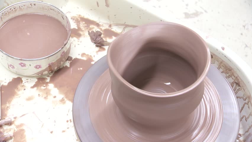 Brown wobbling clay pot spinning on pottery wheel loop