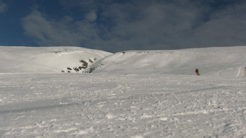 Skier passing in front of the camera and splashing snow