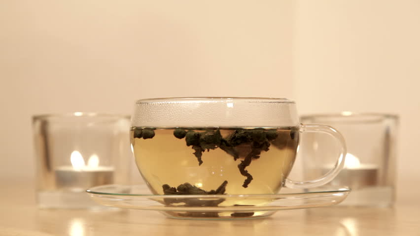Woman inhales aroma of green tea in the glass