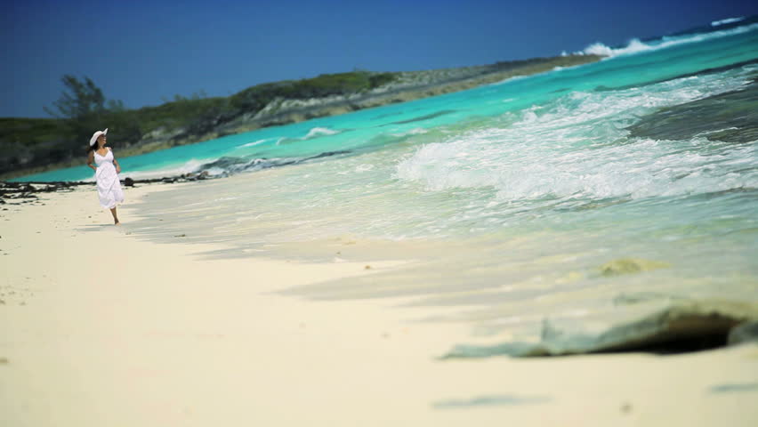 Beautiful elegant female reveling in her lifestyle beside a tropical ocean