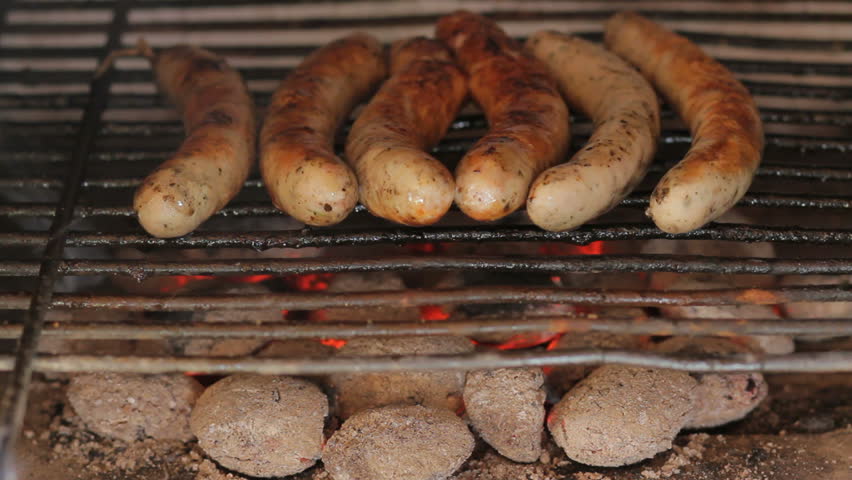 Closeup of Sausages roasting on the garden grill