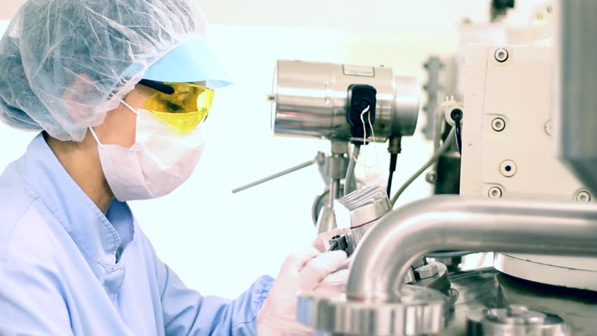 Pharmaceutical technician works in sterile working conditions at pharmaceutical factory. HD 1080p.