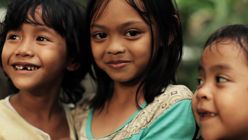 Three indigenous balinese girls posing playful for camera, changing places, laughing and having fun