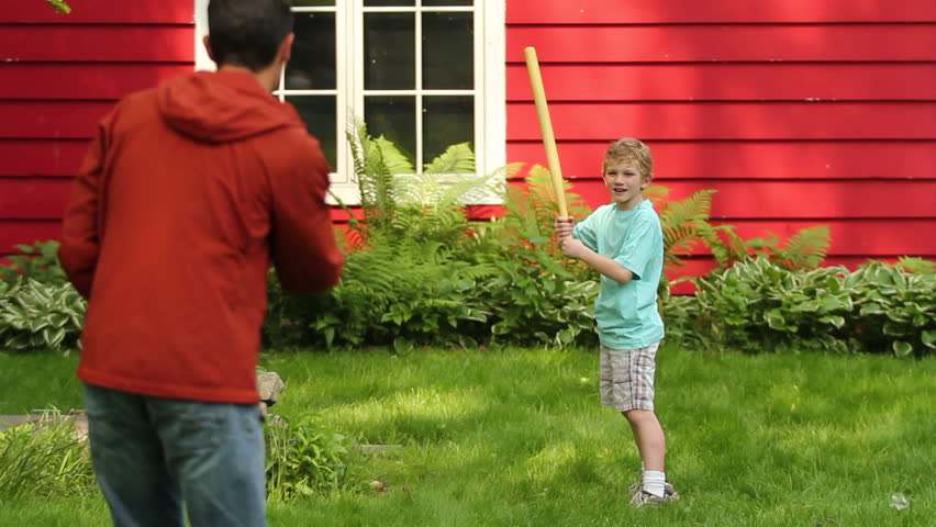 Boy playing baseball in the backyard