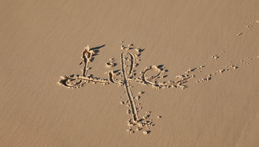 the word life written in the sand gets washed away by a wave