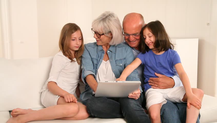 Senior people with grandkids using electronic tablet
